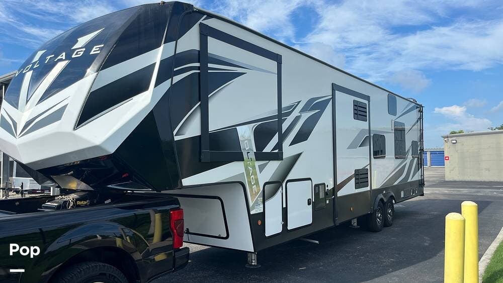 Call now about this 2021 Dutchmen Voltage 3635! 2021 Dutchmen Voltage 3635 - Used Toy Hauler For Sale by Pop RVs in Palmetto, Florida features Leveling Jacks, Generator, Slideout, Air Conditioning, Awning