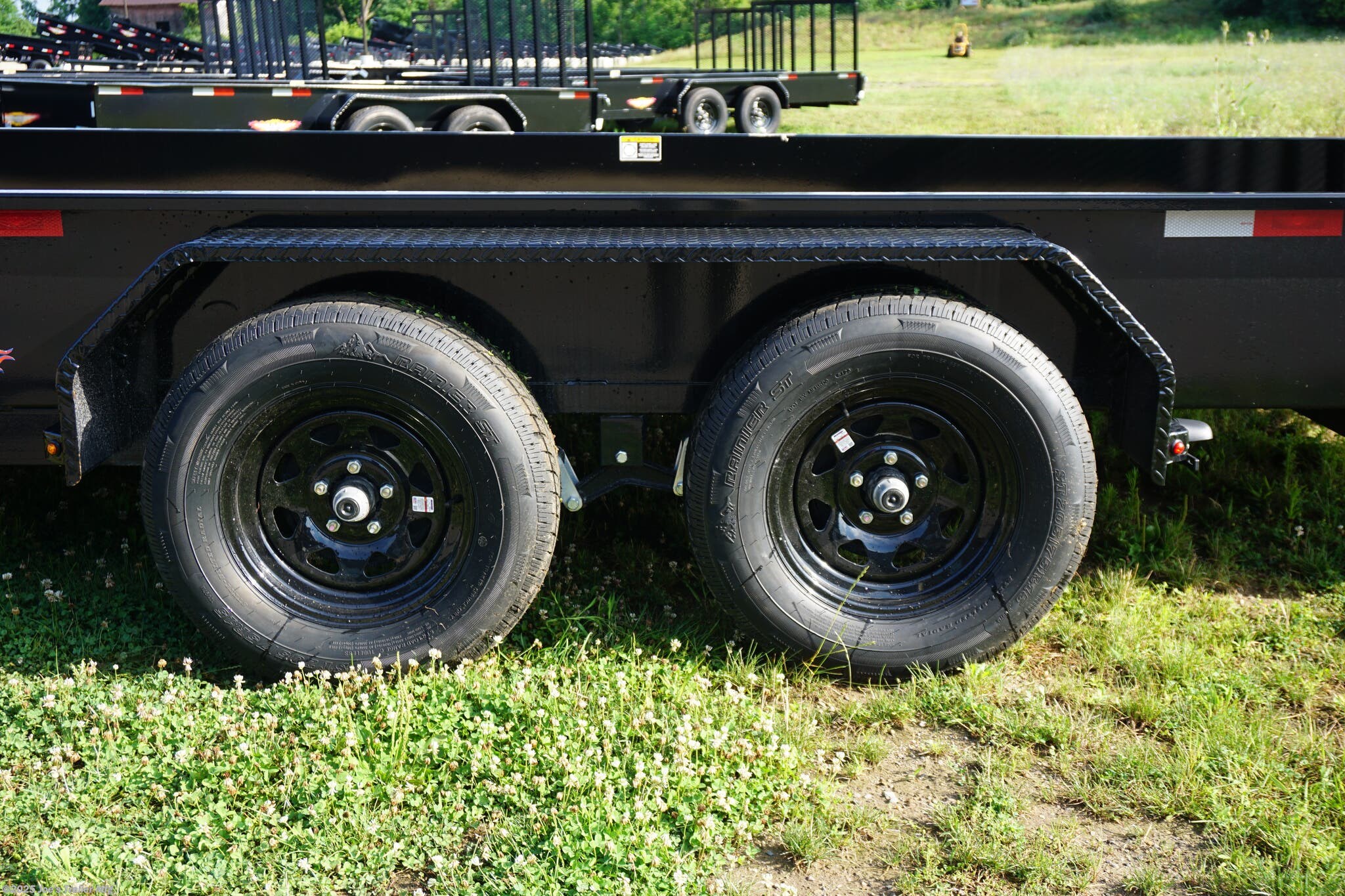 82x20 Tandem Solid Side, 12-Gauge Steel Frame, Steel Angle Crossmembers, 12-Gauge Steel Sides, 15" Tall, 4" Steel Channel Tongue, A-Frame Posi-lock Coupler, Dual Safety Chains and Hooks, 2K Rated Set-Back Jack with Foot, 2x8 Treated, #1 Grade Wood Decking, Welded Front Board Retainer, Welded Rear End Cap, 50" Spring Assisted Gate, Grab Handle, Steel Tread Plate Fenders, Spring Suspension, Easy Lube Hubs, Radial Tires, Black Steel Wheels, Enclosed Sealed Wiring Harness, Full LED Lighting, DOT Compliant Lighting, D-Rings Tie Downs, Spare Tire Mount, Load Angle, Ramp Length, Load Angle: 22°, Ramp Length: 50", ramp pivot point, heavy-duty trailer, utility trailer, equipment trailer, tandem axle trailer, solid side trailer, durable trailer, trailer safety features, easy maintenance trailer, wood decking trailer, radial tire trailer, LED lighting trailer, steel frame trailer, spring suspension trailer, A-frame coupler, safety chains, set-back jack, treated wood decking, spring assisted gate,