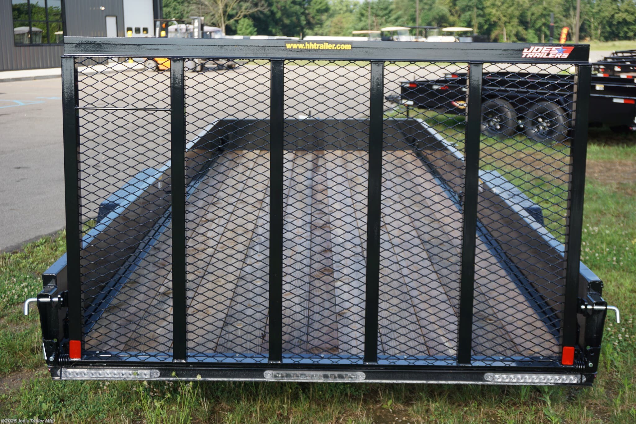 82x20 Tandem Solid Side, 12-Gauge Steel Frame, Steel Angle Crossmembers, 12-Gauge Steel Sides, 15" Tall, 4" Steel Channel Tongue, A-Frame Posi-lock Coupler, Dual Safety Chains and Hooks, 2K Rated Set-Back Jack with Foot, 2x8 Treated, #1 Grade Wood Decking, Welded Front Board Retainer, Welded Rear End Cap, 50" Spring Assisted Gate, Grab Handle, Steel Tread Plate Fenders, Spring Suspension, Easy Lube Hubs, Radial Tires, Black Steel Wheels, Enclosed Sealed Wiring Harness, Full LED Lighting, DOT Compliant Lighting, D-Rings Tie Downs, Spare Tire Mount, Load Angle, Ramp Length, Load Angle: 22°, Ramp Length: 50", ramp pivot point, heavy-duty trailer, utility trailer, equipment trailer, tandem axle trailer, solid side trailer, durable trailer, trailer safety features, easy maintenance trailer, wood decking trailer, radial tire trailer, LED lighting trailer, steel frame trailer, spring suspension trailer, A-frame coupler, safety chains, set-back jack, treated wood decking, spring assisted gate,