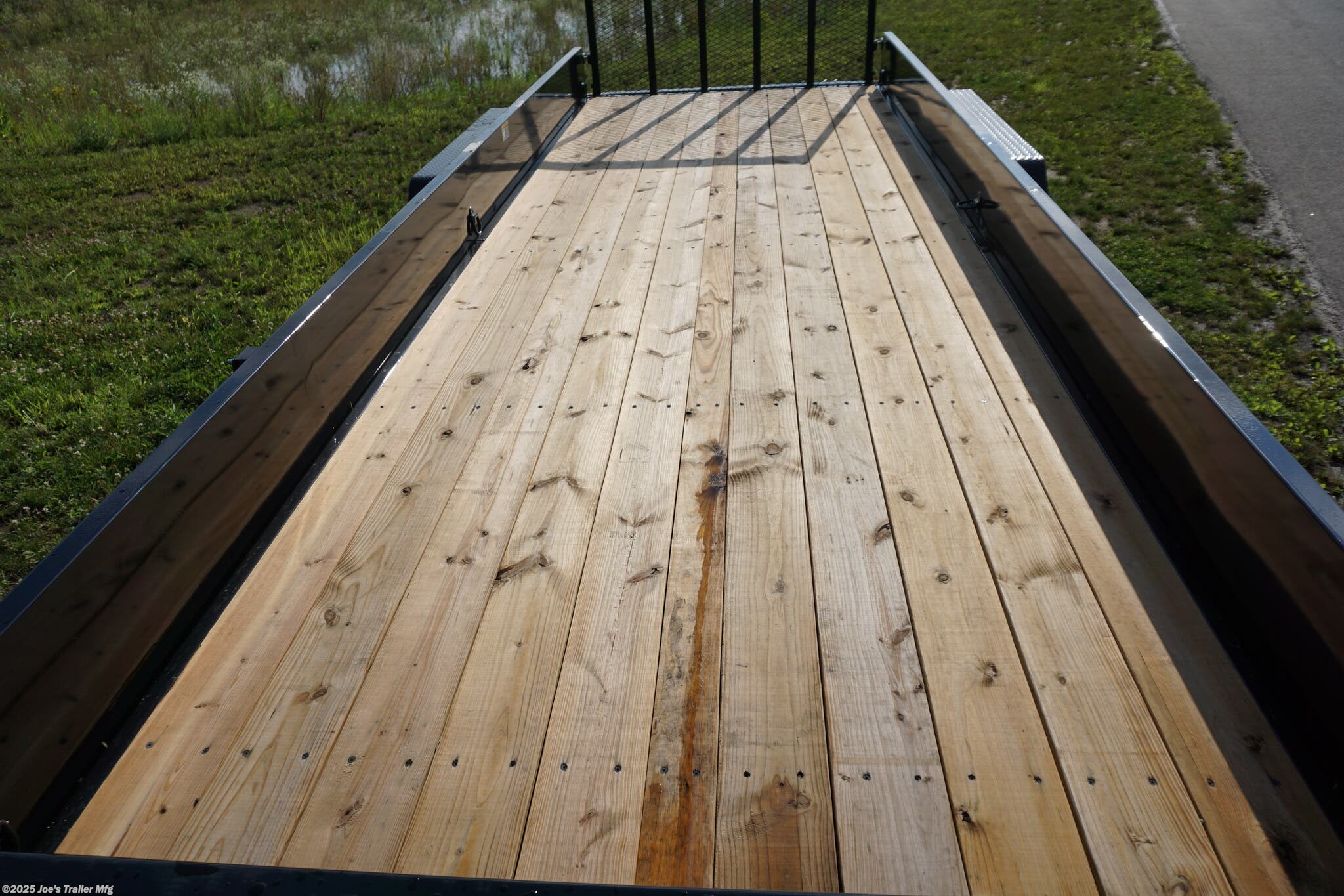 82x20 Tandem Solid Side, 12-Gauge Steel Frame, Steel Angle Crossmembers, 12-Gauge Steel Sides, 15" Tall, 4" Steel Channel Tongue, A-Frame Posi-lock Coupler, Dual Safety Chains and Hooks, 2K Rated Set-Back Jack with Foot, 2x8 Treated, #1 Grade Wood Decking, Welded Front Board Retainer, Welded Rear End Cap, 50" Spring Assisted Gate, Grab Handle, Steel Tread Plate Fenders, Spring Suspension, Easy Lube Hubs, Radial Tires, Black Steel Wheels, Enclosed Sealed Wiring Harness, Full LED Lighting, DOT Compliant Lighting, D-Rings Tie Downs, Spare Tire Mount, Load Angle, Ramp Length, Load Angle: 22°, Ramp Length: 50", ramp pivot point, heavy-duty trailer, utility trailer, equipment trailer, tandem axle trailer, solid side trailer, durable trailer, trailer safety features, easy maintenance trailer, wood decking trailer, radial tire trailer, LED lighting trailer, steel frame trailer, spring suspension trailer, A-frame coupler, safety chains, set-back jack, treated wood decking, spring assisted gate,