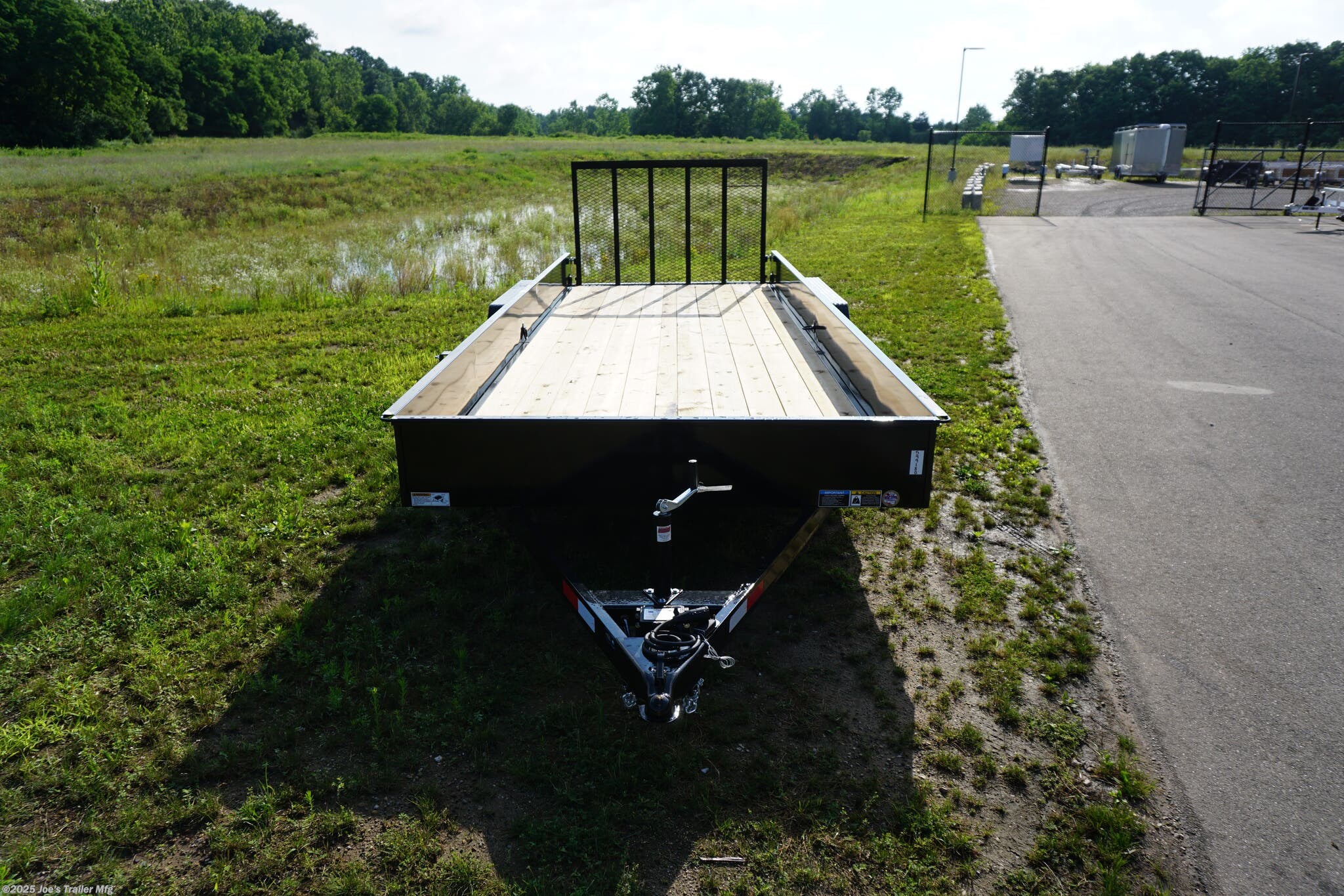 82x20 Tandem Solid Side, 12-Gauge Steel Frame, Steel Angle Crossmembers, 12-Gauge Steel Sides, 15" Tall, 4" Steel Channel Tongue, A-Frame Posi-lock Coupler, Dual Safety Chains and Hooks, 2K Rated Set-Back Jack with Foot, 2x8 Treated, #1 Grade Wood Decking, Welded Front Board Retainer, Welded Rear End Cap, 50" Spring Assisted Gate, Grab Handle, Steel Tread Plate Fenders, Spring Suspension, Easy Lube Hubs, Radial Tires, Black Steel Wheels, Enclosed Sealed Wiring Harness, Full LED Lighting, DOT Compliant Lighting, D-Rings Tie Downs, Spare Tire Mount, Load Angle, Ramp Length, Load Angle: 22°, Ramp Length: 50", ramp pivot point, heavy-duty trailer, utility trailer, equipment trailer, tandem axle trailer, solid side trailer, durable trailer, trailer safety features, easy maintenance trailer, wood decking trailer, radial tire trailer, LED lighting trailer, steel frame trailer, spring suspension trailer, A-frame coupler, safety chains, set-back jack, treated wood decking, spring assisted gate,