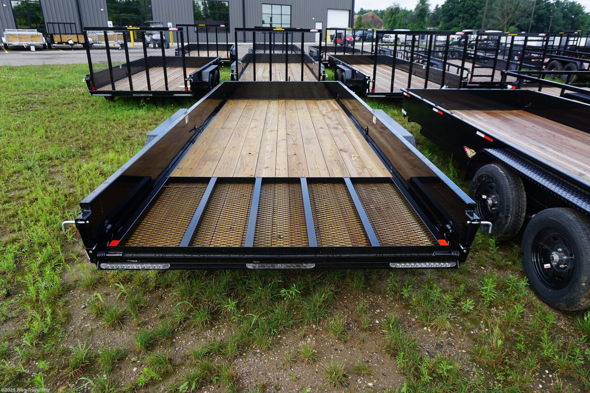 82x20 Tandem Solid Side, 12-Gauge Steel Frame, Steel Angle Crossmembers, 12-Gauge Steel Sides, 15" Tall, 4" Steel Channel Tongue, A-Frame Posi-lock Coupler, Dual Safety Chains and Hooks, 2K Rated Set-Back Jack with Foot, 2x8 Treated, #1 Grade Wood Decking, Welded Front Board Retainer, Welded Rear End Cap, 50" Spring Assisted Gate, Grab Handle, Steel Tread Plate Fenders, Spring Suspension, Easy Lube Hubs, Radial Tires, Black Steel Wheels, Enclosed Sealed Wiring Harness, Full LED Lighting, DOT Compliant Lighting, D-Rings Tie Downs, Spare Tire Mount, Load Angle, Ramp Length, Load Angle: 22°, Ramp Length: 50", ramp pivot point, heavy-duty trailer, utility trailer, equipment trailer, tandem axle trailer, solid side trailer, durable trailer, trailer safety features, easy maintenance trailer, wood decking trailer, radial tire trailer, LED lighting trailer, steel frame trailer, spring suspension trailer, A-frame coupler, safety chains, set-back jack, treated wood decking, spring assisted gate,