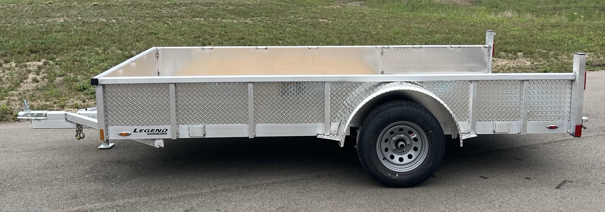 Legend Open Deluxe 7X12 Utility Trailer, 4" Tube Main Frame Utility Trailer, 24" OC Crossmembers Trailer, 15" Side Rails With Skirting, 2" Coupler Trailer, ST205/75R14 Steel Tires Trailer, ATP Fenders Utility Trailer, Treated Wood Decking Trailer, (4) Stake Pockets Utility Trailer, No Brakes Utility Trailer, Load Angle 19° Trailer, Ramp Length 48" Trailer, Ramp Pivot Point Trailer, Heavy Duty Utility Trailer, Durable Utility Trailer, Steel Tires Utility Trailer, Tubular Frame Trailer, Crossmembers Spacing 24" Trailer, Side Rails With Skirting Utility Trailer, Coupler 2" Trailer, Aluminum Fenders Utility Trailer, Wood Decking Treated, Stake Pockets 4 Trailer, Trailer Without Brakes, Load Angle 19 Degrees, Ramp Length 48 Inches, Utility Trailer Specs, Trailer Features, Utility Trailer Specifications, Legend Trailer Features, Deluxe Utility Trailer, Open Utility Trailer