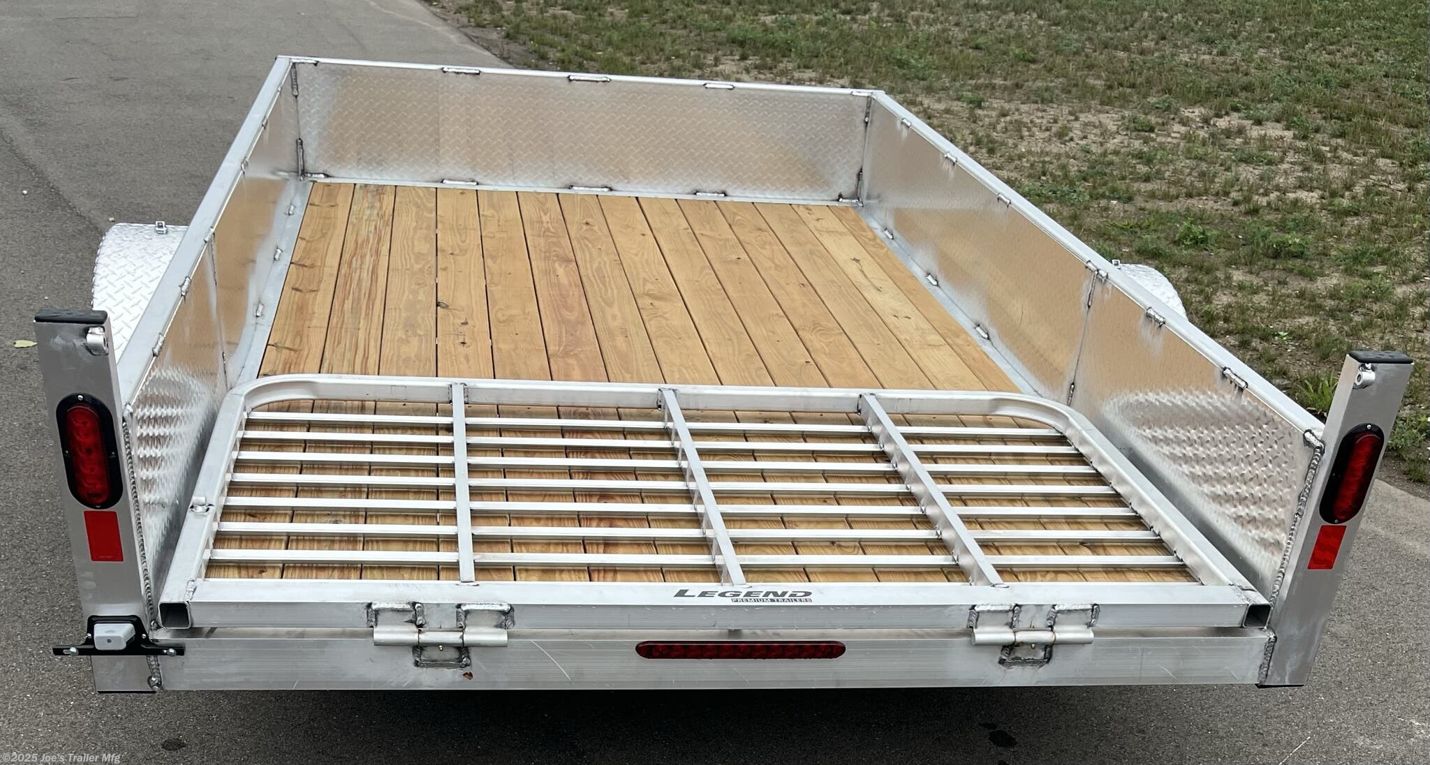 Legend Open Deluxe 7X12 Utility Trailer, 4" Tube Main Frame Utility Trailer, 24" OC Crossmembers Trailer, 15" Side Rails With Skirting, 2" Coupler Trailer, ST205/75R14 Steel Tires Trailer, ATP Fenders Utility Trailer, Treated Wood Decking Trailer, (4) Stake Pockets Utility Trailer, No Brakes Utility Trailer, Load Angle 19° Trailer, Ramp Length 48" Trailer, Ramp Pivot Point Trailer, Heavy Duty Utility Trailer, Durable Utility Trailer, Steel Tires Utility Trailer, Tubular Frame Trailer, Crossmembers Spacing 24" Trailer, Side Rails With Skirting Utility Trailer, Coupler 2" Trailer, Aluminum Fenders Utility Trailer, Wood Decking Treated, Stake Pockets 4 Trailer, Trailer Without Brakes, Load Angle 19 Degrees, Ramp Length 48 Inches, Utility Trailer Specs, Trailer Features, Utility Trailer Specifications, Legend Trailer Features, Deluxe Utility Trailer, Open Utility Trailer