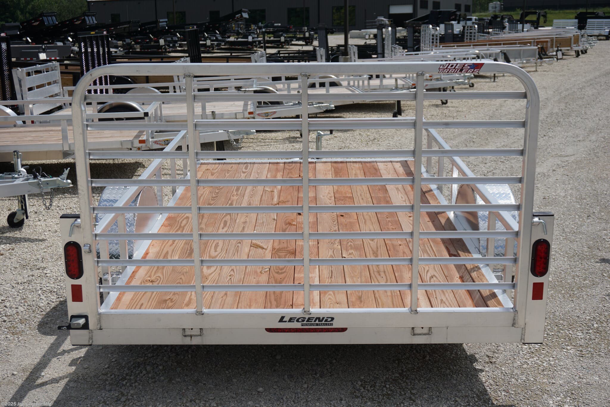 Legend 7x12 Open Deluxe Utility Trailer, 17" deck height utility trailer, 48" ramp gate trailer, 3.5k EZ-Lube spring axle, ST205/75R14 Silver Mod steel tires, 3" tube cross members, 24" on center cross member spacing, 4" tube frame trailer, aluminum flooring utility trailer, LED lighting trailer, 2" straight coupler, 2k top-wind jack, ATP fenders, stake pockets, aluminum utility trailer, open deluxe trailer, Legend utility trailer, lightweight utility trailer, durable trailer frame, trailer with LED lights, easy-to-lube axle, high-quality utility trailer, trailer with ramp gate, spring axle utility trailer, Legend trailer features, utility trailer with aluminum flooring, adjustable coupler trailer, top-wind jack utility trailer, trailer with ATP fenders, customizable utility trailer, Legend open trailer, utility trailer for heavy loads, trailer for equipment transport, low-profile utility trailer, trailer with stake pockets, utility trailer for landscaping, 12' utility trailer, trailer