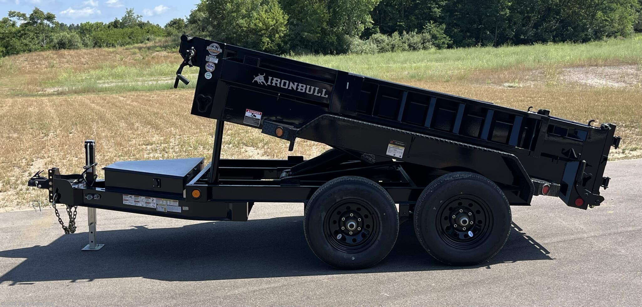 IronBull 5x10 dump trailer, 5x10 dump trailer, 5x10 trailer, IronBull dump trailer, 5x10 dump trailer with 5.2K axles, 2.8 cubic yard dump trailer, dual 6-inch I-Beam frame, 7 gauge steel flooring, heavy-duty steel trailer, 4-inch tubing bed frame, 10 gauge steel sides, 18-inch steel sides, standard retractable tarp kit, 10k drop leg jack, scissor lift dump trailer, adjustable coupler trailer, 2 5/16-inch adjustable coupler, spare tire mount, ramps mounted to side, rear support stand bracket, three-way spreader gate, Powdura powder coat, one cure primer, locking pump box, standard stake pockets, weld-on diamond plate fenders, 5/8-inch D-rings, floor-mounted D-rings, DOT approved LED lighting, lifetime LED lighting, trailer with brakes, equipped brakes, LED voltage indicator, remote control for dump trailer, built-in 5 amp battery charger, heavy-duty dump trailer, small dump trailer, compact dump trailer, versatile dump trailer, farm dump trailer, landscaping dump trailer, construction