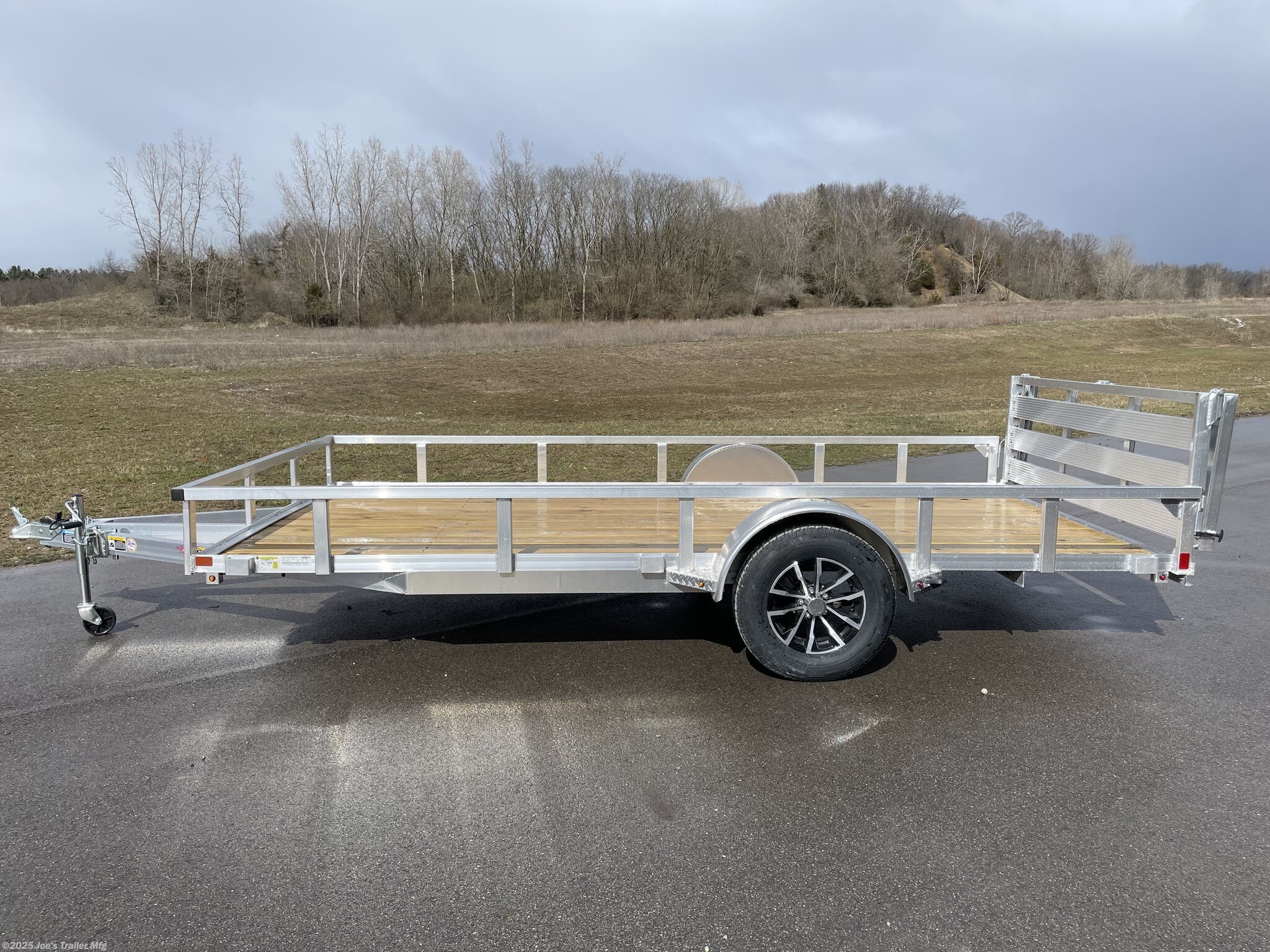 Utility Trailer H & H 7 X 14 Aluminum Rail Side, 3 X 2 Angle Aluminum Extrusion Frame, Aluminum Extrusion Tube Upright Sides, 2 x 2 Tube Top Rail, Aluminum Triple Tube Tongue, Treated Wood Deck, 15" Aluminum Wheels, 15" Radial Tires, A-Frame Posi-lock Coupler, Dual Safety Chains & Hooks, Swivel Jack with Caster Wheel, LED Lighting, Sealed Wiring Harness, Aluminum Stake Pockets, 54" Bi-Fold Gate, Brakes: None, Load Angle & Ramp Length, Load Angle: 17°, Ramp Length: 58", Ramp Pivot Point Measurements, Aluminum Trailer Accessories, Heavy Duty Aluminum Trailer, Aluminum Extrusion Components, Trailer Parts and Accessories, Custom Aluminum Trailer Features, Durable Aluminum Trailer, LED Trailer Lighting, Swivel Jack Trailer Equipment, Safety Chains and Hooks, Aluminum Stake Pocket Design, Treated Wood Decking for Trailers, 15" Radial Trailer Tires, A-Frame Coupler Trailer, Bi-Fold Gate Trailer, High-Quality Aluminum Wheels, Ramp Length Specifications, Trailer Load Angle, Aluminum Extrusion T