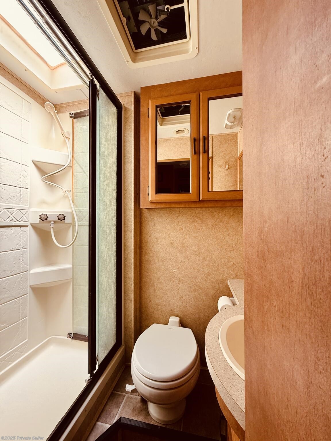 Bathroom with shower stall, toilet, sink and cabinets