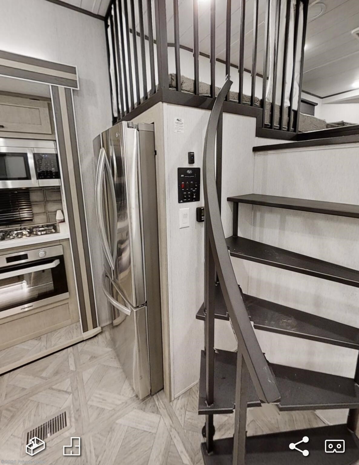 Walking into the unit facing kitchen and spiral stairs up above the master bedroom 